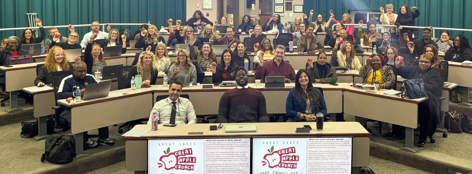 Great Apple Crunch event group photo with nearly a hundred educators holding up an apple
