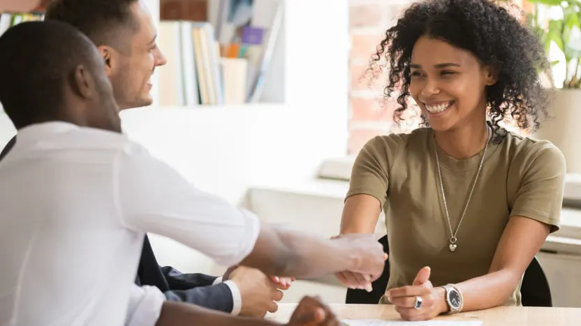 woman shaking hands with men in office new employment